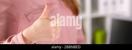 Mädchen in Geschäftskleidung zeigt Zustimmungsgeste Stockfoto