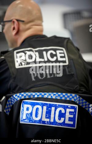 Schild der Polizistin auf der Rückseite des Uniformmantels eines Polizisten Stockfoto