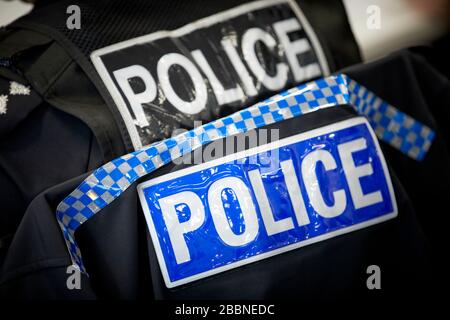 Schild der Polizistin auf der Rückseite des Uniformmantels eines Polizisten Stockfoto