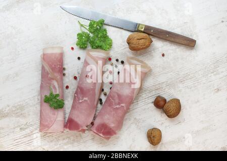 Schinkenscheiben mit Kräutern auf einem Tisch Stockfoto