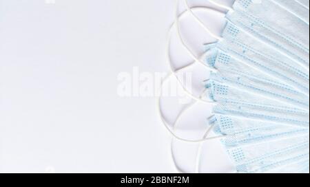 Die Anordnung der medizinischen Masken ist links vom weißen Hintergrund angeordnet. Einfaches flaches Layout mit Kopierbereich. Medizinisches Konzept. Stockfoto
