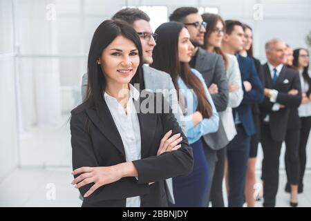 Junge Geschäftsfrau steht vor ihren Kollegen Stockfoto