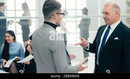 Ernster Chef erklärt seinem Assistenten etwas Stockfoto