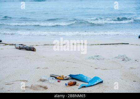 Müllzusammensetzung an einem weißen Sandstrand eines Ozeanufers Stockfoto