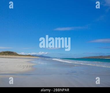 Fantastischer Strand von Luskentire, Insel Harris, Äußere Hebriden, Schottland mit Hügeln von Harris im Hintergrund blauer Himmel und klarem türkisfarbenem Meer Stockfoto