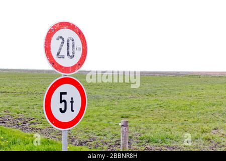 Alte und neue Straßenschilder 20 km/h und maximal 5 Tonnen auf dem Land in Norddeutschland. Stockfoto