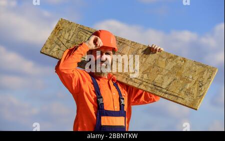 Provisorische Ausrüstung oder Strukturen zusammenbauen. Sanierungsdienste. Man trägt Faserplatten. Holzwerkzeugnis. Faserplatten, die im Wohn- und Geschäftsbau verwendet werden. Gerüste aufstellen. Stockfoto