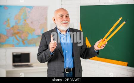 Fehler überprüfen. Bärtiger Tutor zeichnet mit Kompass auf der Tafel. Zurück zur Schule. Mathematische Grafikwerkzeuge Konzept. Lernen Sie Mathematik, um gute Ergebnisse zu erzielen. Lehrer für leitende Männer verwenden Kompasswerkzeug. Stockfoto