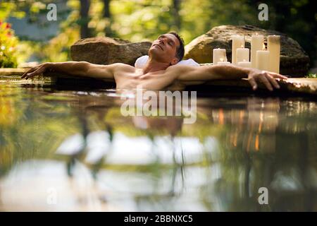 Mittelerwachsener Mann, der sich in einem heißen Frühling erholte. Stockfoto