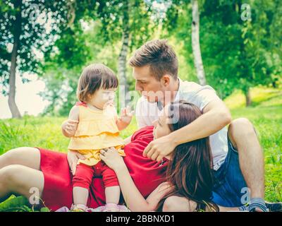 Frech kleines Baby und Eltern mit müdem und unzufriedenem Ausdruck. Eltern sind des Babykonzepts müde Stockfoto