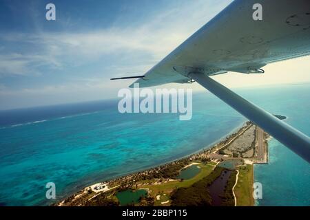 Flugzeug über einer tropischen Insel fliegen. Stockfoto