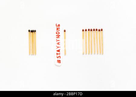 Bleiben Sie zu Hause als #stayathome. Konzept, wie man die Ausbreitung des Coronavirus verhindert. Matchstäbchen brennen, ein Stück verhindert, dass sich das Feuer ausbreitet Stockfoto