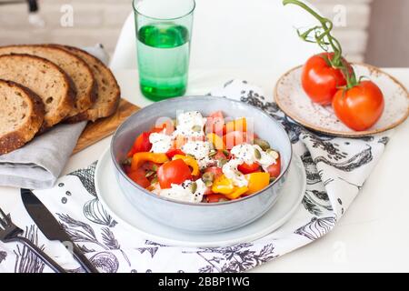 Frischer gesunder Salat mit Tomaten, gegrilltem Pfeffer, Käse, Kürbissamen und schwarzem Sesam. Homemeade Sommergericht. Stockfoto