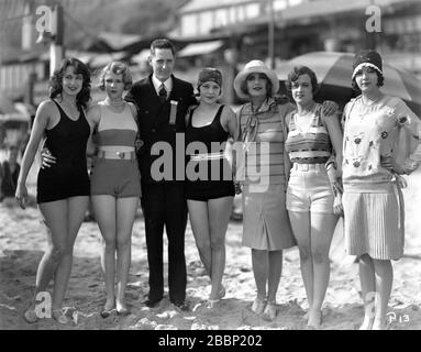 MACK SENNETT BADESCHÖNHEITEN KATHRYN STANLEY LEOTA WINTER MADELINE HURLOCK CAROLE LOMBARD MARIE PERGAIN UND NANCY CORNELIUS POSIEREN MIT L.M. COBBS Portland Movie Theatre Manager/Kinobetreiber am Strand im Jahr 1928 Mack Sennett Comedies/Pathe Exchange Stockfoto