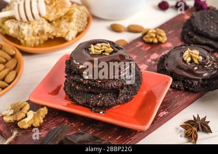 Veganes, vegetarisches Rohkost gesundes Nussbananenschokoladengebäck auf weißem Holzhintergrund. Hausgemachtes aus Datteln, Walnüssen, Mandeln und Chocola Stockfoto