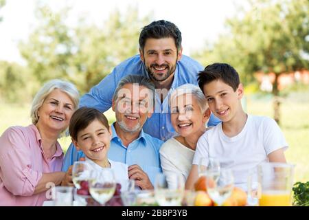Familie sitzen beim Mittagessen im Garten Stockfoto
