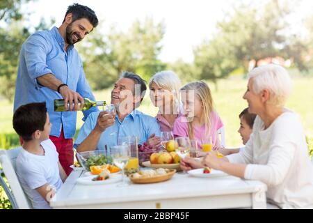 Familie sitzen beim Mittagessen im Garten Stockfoto