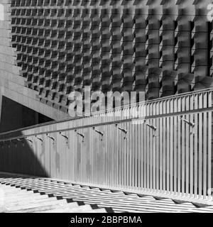 Parallele Reihen von abgewinkelten Kalksteinblöcken an der Fassade des Parlamentshauses von Renzo Piano in Valletta kontrastieren mit einem aufsteigenden Stahlhandlauf. Stockfoto