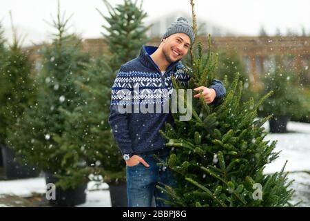 Junger Mann Kauft Weihnachtsbaum Stockfoto