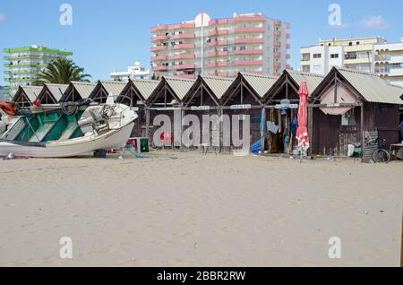 Monte Gordo, Portugal - 18. November 2019: Ein Fischerboot wird neben den Fischerhütten am Strand von Monte Gordo an der A Portugals repariert Stockfoto