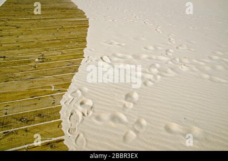 Sandstrände, die auf einem Holzsteg eindringen. Badeort Monte Gordo, Küste der Algarve, Portugal. Stockfoto