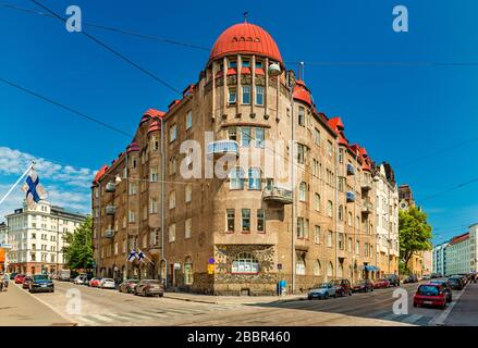 Helsinki - Juni 2019, Finnland: Ein Gebäude im historischen Teil von Helsinki. Blick auf eine Straße mit geparkten Autos und einem alten Gebäude Stockfoto