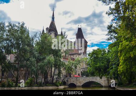 Historisches Gebäude in Budapest - Schloss Vajdahunyad mit See über dem übergiebelten Himmel im Hauptstadtpark Stockfoto
