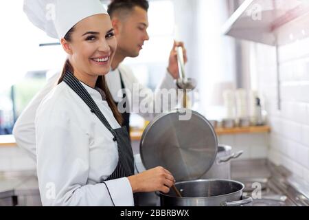 Weibliche und männliche Köche in der Küche Stockfoto