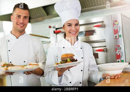 Weibliche und männliche Köche in der Küche Stockfoto