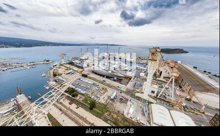 Luftaufnahme des Trockendocks in La Ciotat, Frankreich, Frachtkran, Reparaturboote, Luxussegelyacht und Motoryacht, Berg Stockfoto