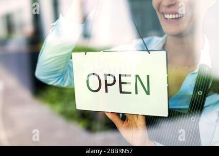Frau mit offenem Schild im Café Stockfoto