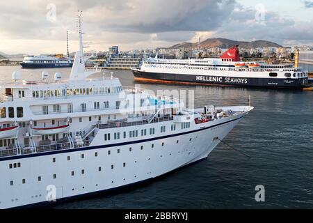 Das Kreuzfahrtschiff MV Aegean Odyssey und eine Fähre der Hellenic Seaways im Hafen von Piräus in Griechenland. Stockfoto