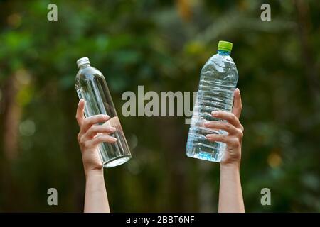 Halten Sie das leere Glas und die Plastikflasche in der Hand Stockfoto