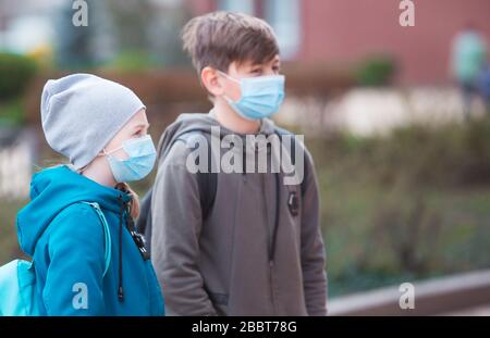 Stadtbewohner Erwachsene und Kinder beobachten Quarantäne und gehen in Masken Stockfoto