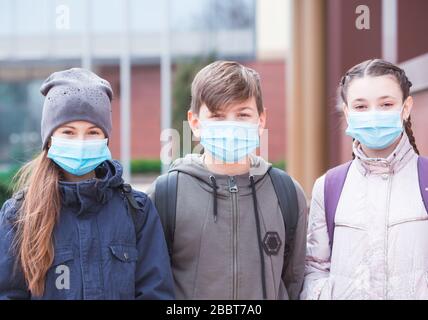 Stadtbewohner Erwachsene und Kinder beobachten Quarantäne und gehen in Masken Stockfoto