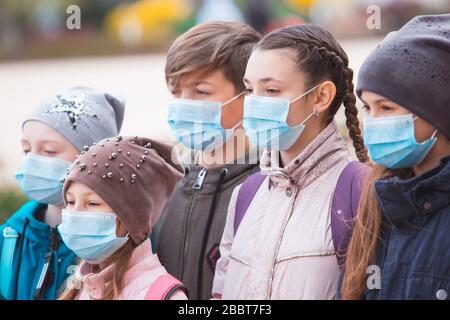 Stadtbewohner Erwachsene und Kinder beobachten Quarantäne und gehen in Masken Stockfoto