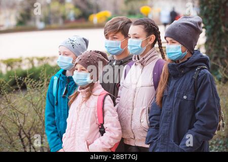 Stadtbewohner Erwachsene und Kinder beobachten Quarantäne und gehen in Masken Stockfoto