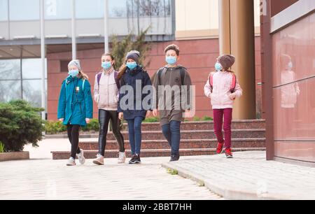 Stadtbewohner Erwachsene und Kinder beobachten Quarantäne und gehen in Masken Stockfoto