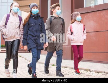 Stadtbewohner Erwachsene und Kinder beobachten Quarantäne und gehen in Masken Stockfoto