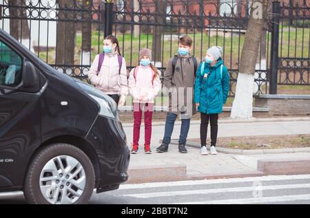 Stadtbewohner Erwachsene und Kinder beobachten Quarantäne und gehen in Masken Stockfoto