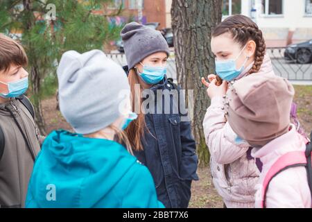 Stadtbewohner Erwachsene und Kinder beobachten Quarantäne und gehen in Masken Stockfoto