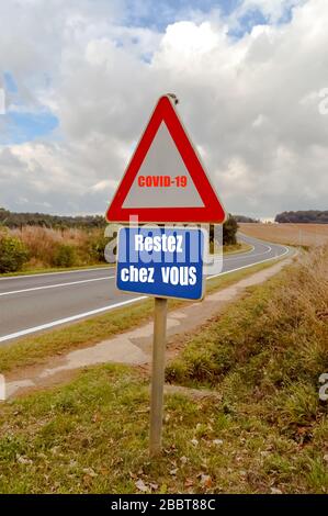 Covid-19 Straßenschild: Bleiben Sie vor dem Hintergrund der Landschaft zu Hause Stockfoto