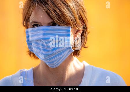 Frau, die eine Atemmaske trägt, selbstgenäht, aus Baumwolle, Auswirkungen der Koronakrise in Deutschland, Stockfoto