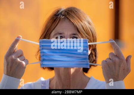 Frau, die eine Atemmaske trägt, selbstgenäht, aus Baumwolle, Auswirkungen der Koronakrise in Deutschland, Stockfoto