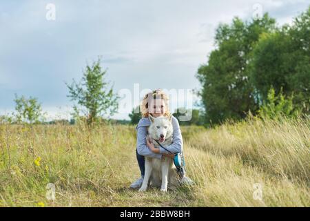 Teenager-Mädchen umarmt Hund, Freundschaftspflege und Liebe zwischen Kind und Haustier Stockfoto