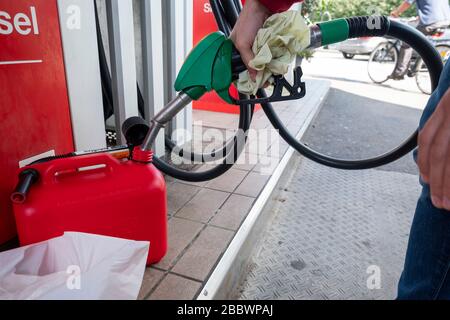 Person, die einen jerrycan-Tankcontainer an einer Tankstelle befüllt Stockfoto