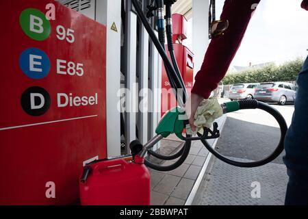 Person, die einen jerrycan-Tankcontainer an einer Tankstelle befüllt Stockfoto