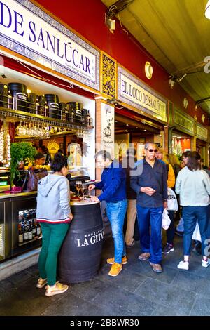 Menschen, die Tapas auf dem Triana-Markt (Mercado de Triana), Sevilla, Andalusien, Spanien, stehen und essen Stockfoto