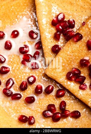 Pfannkuchen mit Granatapfel und Kondensmilch. Makro. Draufsicht. Stockfoto