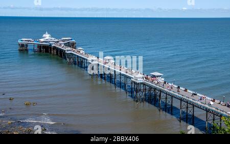 Urlauber am Llandudno Pier, Badeort Llandudno, Nordwales, Großbritannien. Mit 2.295 Fuß ist der Pier der längste in Wales. Stockfoto